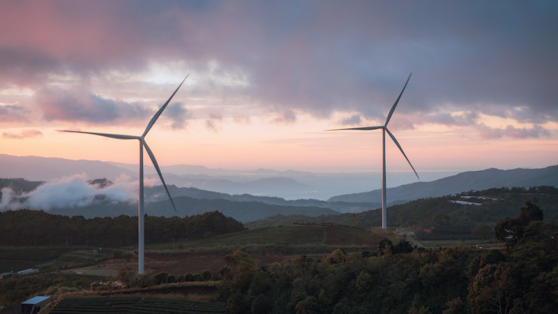 Wind turbines on rolling hills at sunset